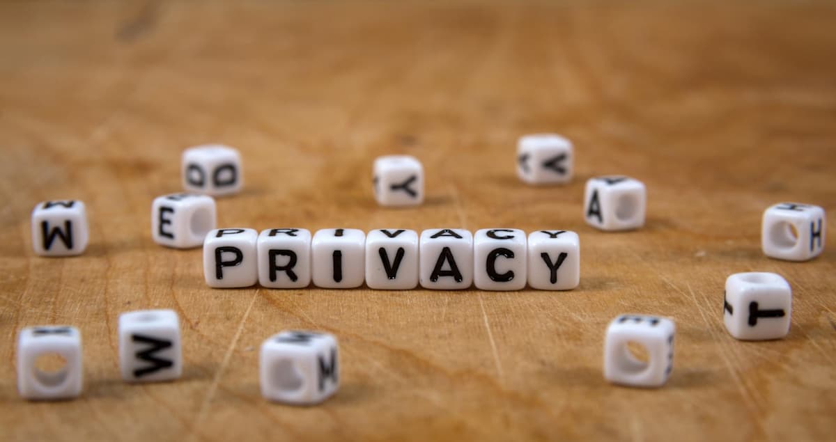 White letter cubes spelling the word privacy on a wooden table surface