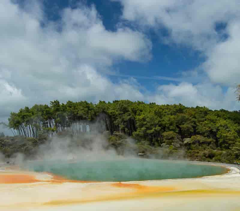 Steaming Champagne Pool at Wai-O-Tapu Thermal Wonderland with vibrant orange and green mineral colors near Rotorua, New Zealand.